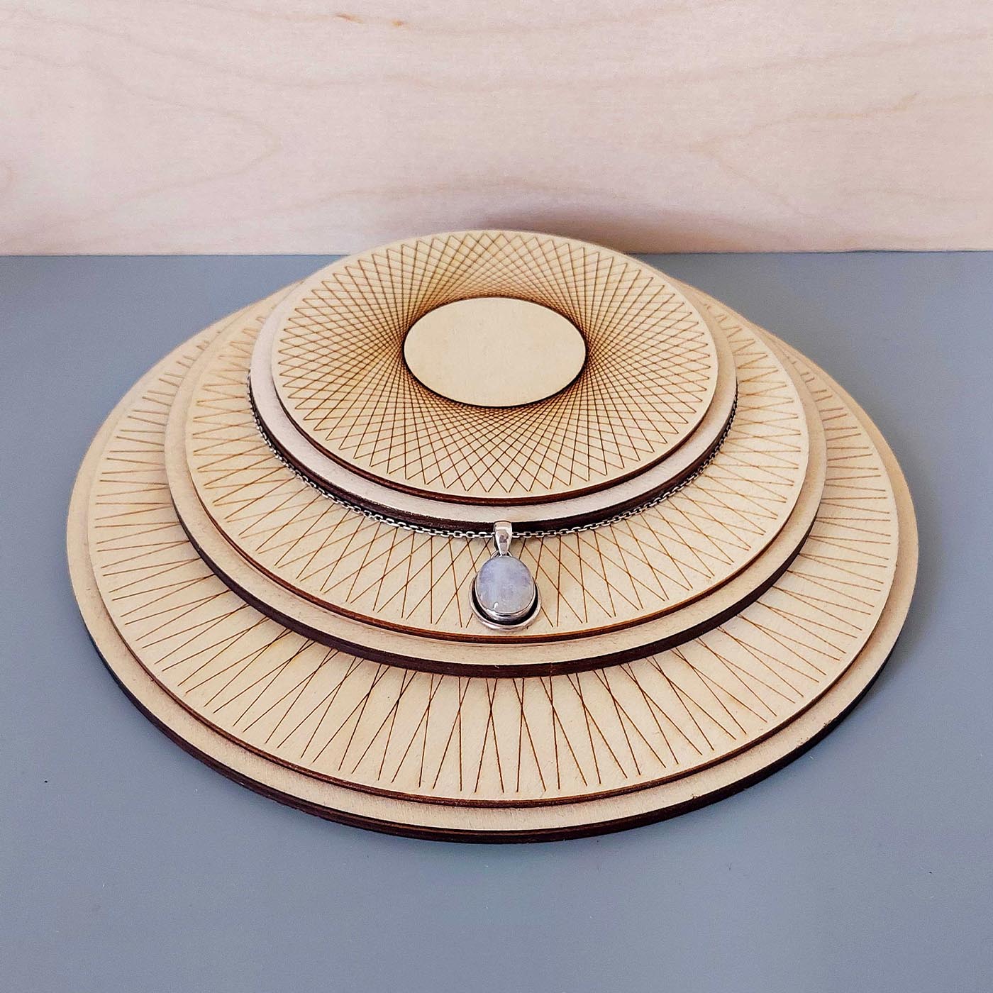 3 plateaux de présentation de bijoux superposés en bois gravé avec un collier